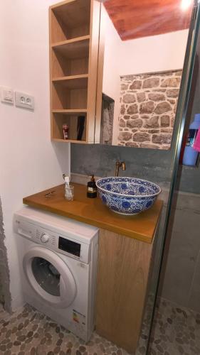 a bathroom with a sink and a washing machine at Beach House Buljarica in Petrovac na Moru