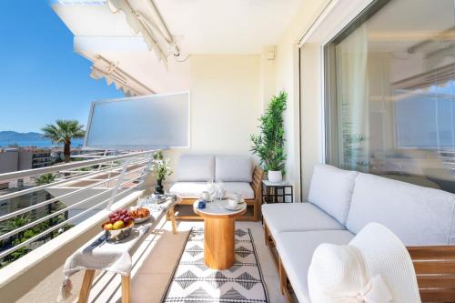 d'un salon avec un canapé et une télévision sur un balcon. dans l'établissement 2-Br Apartment with Sea View Terrace Cannes, à Cannes