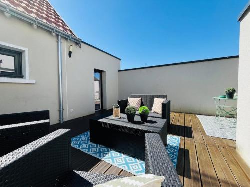 d'une terrasse avec deux canapés et une table. dans l'établissement Casa Belfort - T2, à Angers