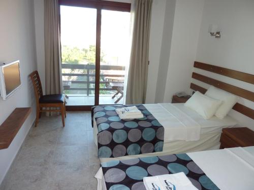 a hotel room with two beds and a balcony at Hotel Silvanus in Oren