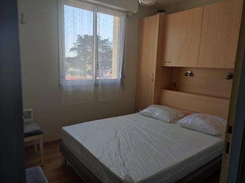 - une petite chambre avec un lit et une fenêtre dans l'établissement Appartement T2 450m de la plage des demoiselles, avec garage et possibilité de vélos à 950m de la rue piétonne, à Saint-Hilaire-de-Riez