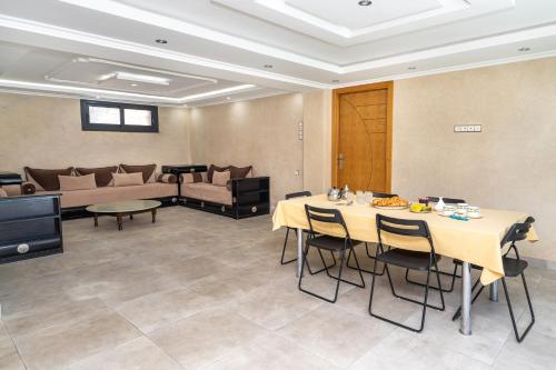 a room with a table with chairs and a couch at Villa Ibn Batouta piscine 8x3 sans vis a vis in Tangier