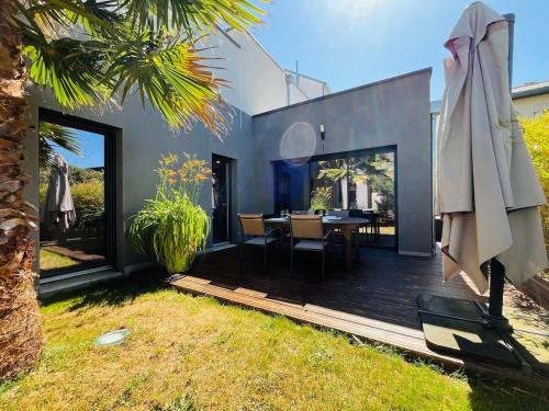 Cette maison dispose d'une terrasse avec une table et un parasol. dans l'établissement Casa Belfort - T3, à Angers