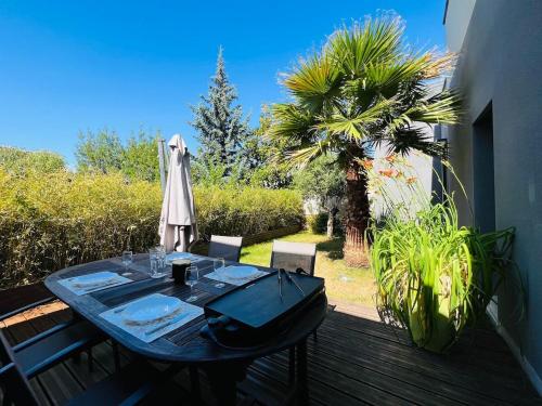une table sur une terrasse avec un parasol dans l'établissement Casa Belfort - T3, à Angers
