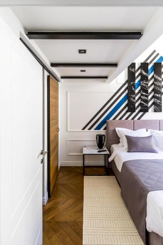 a bedroom with a large bed and a staircase at DeZign Superior Apartments & Rooms in Zadar