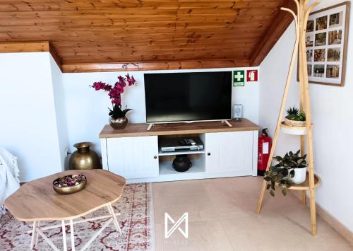 a living room with a flat screen tv on a white cabinet at MyStay - Casa Sete Lano in Pedrógão