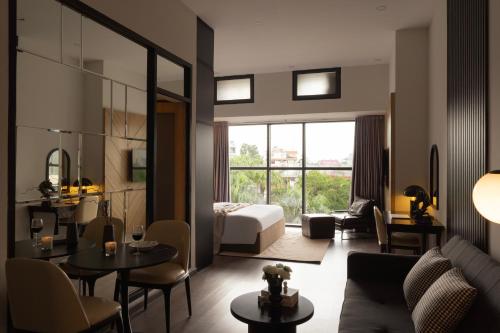 a living room with a couch and a bed and a table at DingD0ng Suites - The Sun Avenue - Free Pool & Gym in Ho Chi Minh City