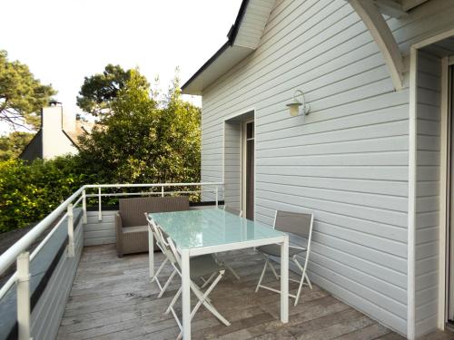 a patio with a table and chairs on a balcony at La Villa Bel Ange Hotel in Saint-Philibert
