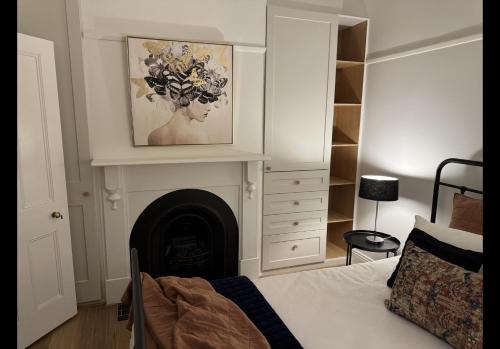 a bedroom with a fireplace with a picture on the wall at Eyre Cottage in Ballarat