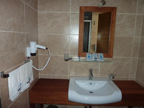 ein Bad mit einem Waschbecken und einem Spiegel in der Unterkunft Hotel Silvanus in Oren