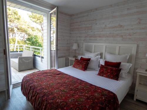 a bedroom with a large bed and a balcony at La Villa Bel Ange Hotel in Saint-Philibert