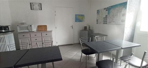 a dining room with two tables and chairs and a kitchen at LE RUN AR MOR 22 in Bas Kerhain