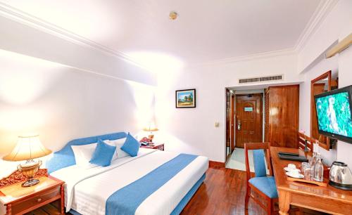 a hotel room with a bed and a tv at Hotel Somadevi Angkor Resort & Spa in Siem Reap