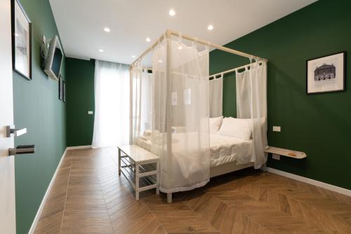 a bedroom with a canopy bed in a green room at Puglialux in Bari
