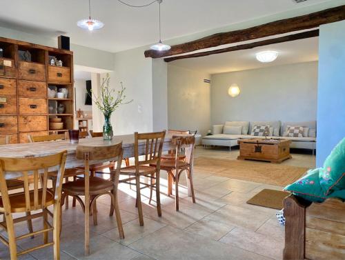 Un comedor y una sala de estar con mesa y sillas. en Domaine Saint Sauveur - 15 pers, en Chantemerle-les-Blés