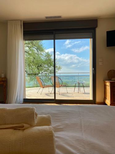 une chambre avec un lit et une vue sur un balcon dans l'établissement Domaine Saint Sauveur - 15 pers, à Chantemerle-les-Blés