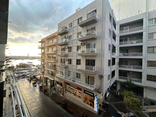 a tall white building with a street in front of it at Sea Breeze Retreat - Comfort Apartments in the Heart of Sliema in Sliema