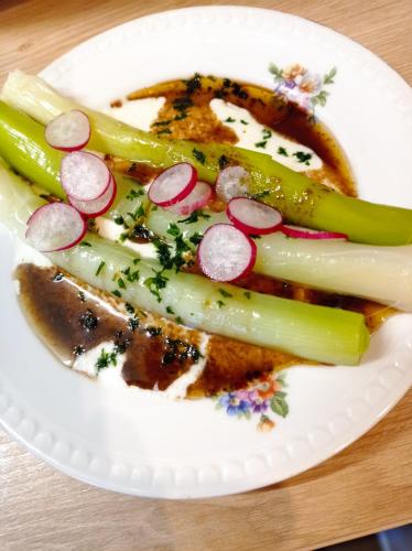 une plaque blanche avec du poisson et des légumes sur une table dans l'établissement AU COEUR DU MARAIS, à Saint-Hilaire-la-Palud