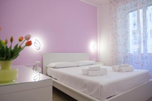una camera da letto bianca con un letto bianco e una finestra di RainbHome Colourful Roman Suites a Roma