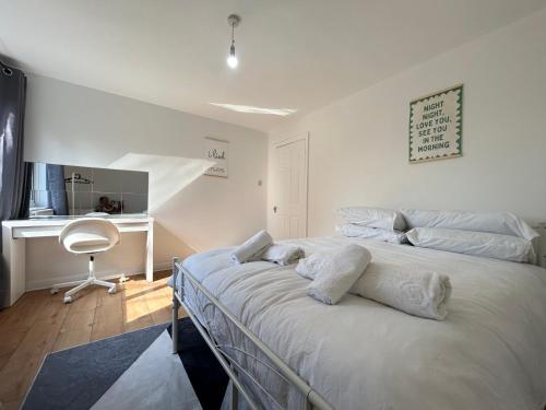 a bedroom with a bed with white sheets and a desk at 2 bed flat in Purley Less than 30 minutes to central London in Purley