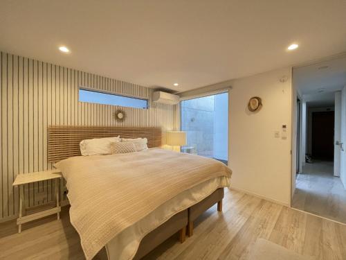 a bedroom with a large bed and a window at Hayama Morito Beach Seascape Villa - 葉山 森戸海岸 Seascape Villa in Hayama