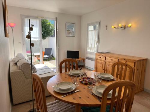 - une table à manger avec des assiettes et des verres à vin dans l'établissement ღ Le Vauban de Ré - Plein Centre & Garage, à Saint-Martin-de-Ré