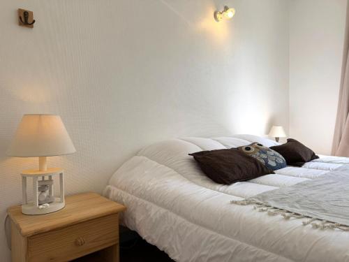 une chambre avec un lit et une table de chevet avec une lampe dans l'établissement ღ Le Vauban de Ré - Plein Centre & Garage, à Saint-Martin-de-Ré
