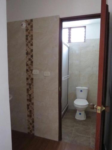 a bathroom with a toilet and a glass shower door at Apartamento Completo Socorro Santander 3 Habitaciones in Socorro