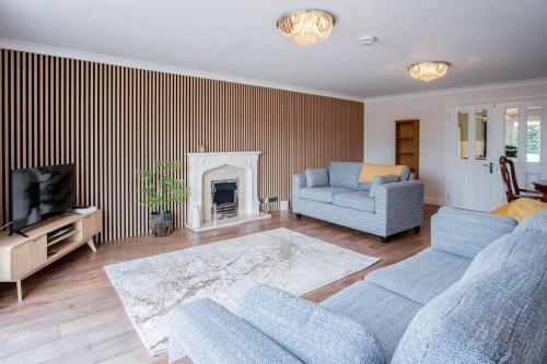 a living room with a couch and a fireplace at Ridgeway Meadow Bungalow - 3 Bedroom - Manorbier in Manorbier
