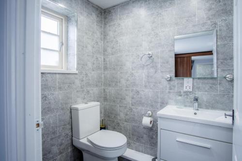 a bathroom with a white toilet and a sink at Ridgeway Meadow Bungalow - 3 Bedroom - Manorbier in Manorbier