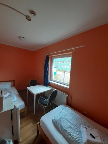 a room with two beds and a window and a desk at 2-Rent Group Hostel Rooms&Apartments TUB19A in Munich