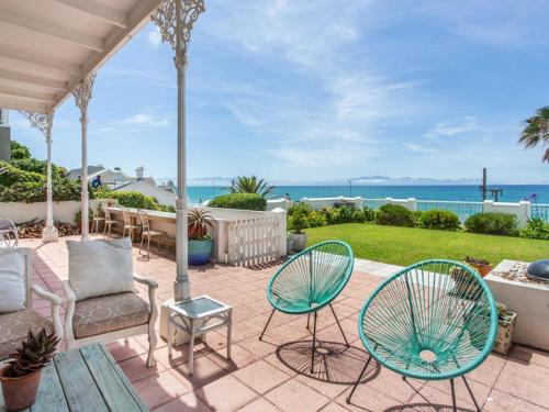 a patio with chairs and tables and the ocean at St James Beachfront Villa in St James