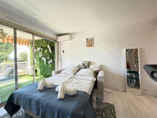 une chambre avec deux lits et une grande fenêtre dans l'établissement Beach Studio in Golfe-Juan near Cannes and Antibes, au Golfe-Juan