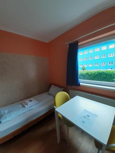 a small room with a bed and a table and a window at 2-Rent Group Hostel Rooms&Apartments TUB19A in Munich