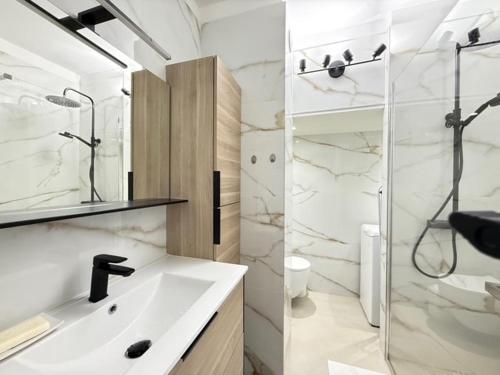 une salle de bain blanche avec un lavabo et une douche dans l'établissement Beach Studio in Golfe-Juan near Cannes and Antibes, au Golfe-Juan