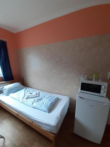 a bedroom with a bed with a microwave on it at 2-Rent Group Hostel Rooms&Apartments TUB19A in Munich