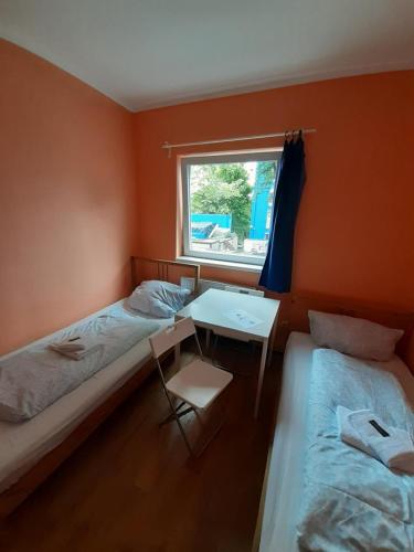 a room with two beds and a table and a window at 2-Rent Group Hostel Rooms&Apartments TUB19A in Munich