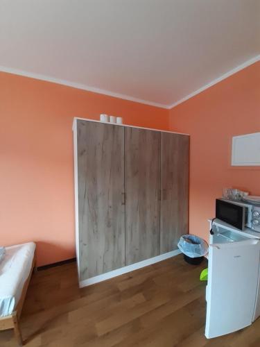 a kitchen with a large wooden cabinet in a room at 2-Rent Group Hostel Rooms&Apartments TUB19A in Munich