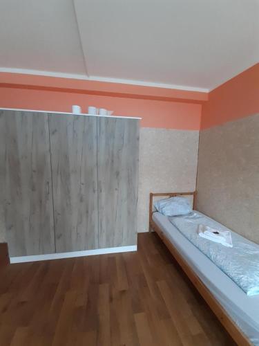 a room with a bed and a wooden wall at 2-Rent Group Hostel Rooms&Apartments TUB19A in Munich