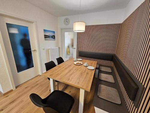 Ferienhaus Nr 96, Kategorie Komfort Plus, Feriendorf Hochbergle, Allgäu في Karlsebene: غرفة طعام مع طاولة وكراسي خشبية