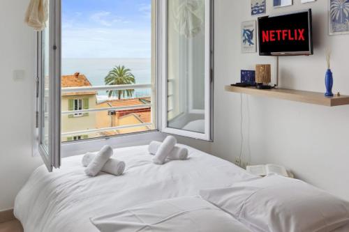 une chambre avec un lit avec une grande fenêtre dans l'établissement L'Azur - Seaview - AC - Tram - WIFI - Airport, à Nice