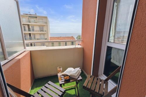 - un balcon avec une table, des chaises et un verre de vin dans l'établissement L'Azur - Seaview - AC - Tram - WIFI - Airport, à Nice