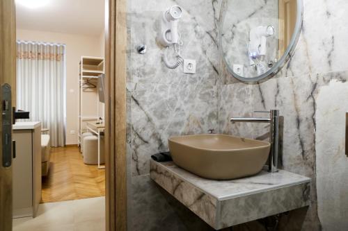 a bathroom with a bowl sink and a mirror at Best House Cleo Pasalimani Piraeus in Piraeus