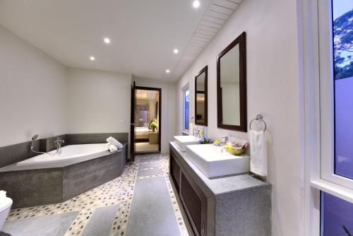 a bathroom with two sinks and a bath tub and a tub at Baan Rim Talay in Nathon