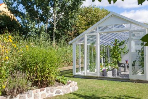a white greenhouse in a garden at Lovely appartment in charming town house in Assens