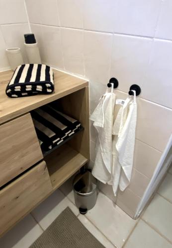 La salle de bains est pourvue de serviettes blanches accrochées au mur. dans l'établissement Loft du Mistral Charme Cinéma Allauch, à Allauch