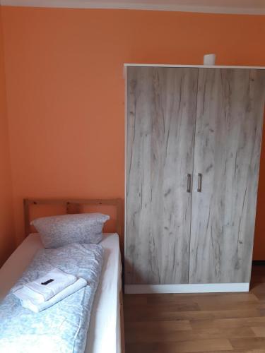 a bedroom with a bed and a wooden cabinet at 2-Rent Group Hostel Rooms&Apartments TUB19A in Munich