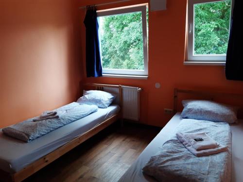 two beds in a room with two windows at 2-Rent Group Hostel Rooms&Apartments TUB19A in Munich