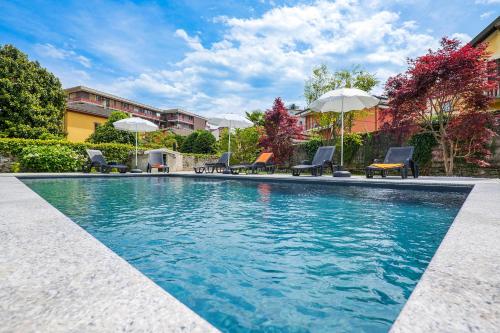 una piscina con sillas y sombrillas en Villa Rachel Trilo, en Intra