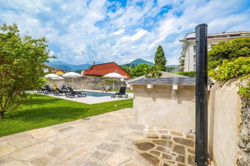 un patio trasero con una pared de piedra y una piscina en Villa Rachel Trilo, en Intra